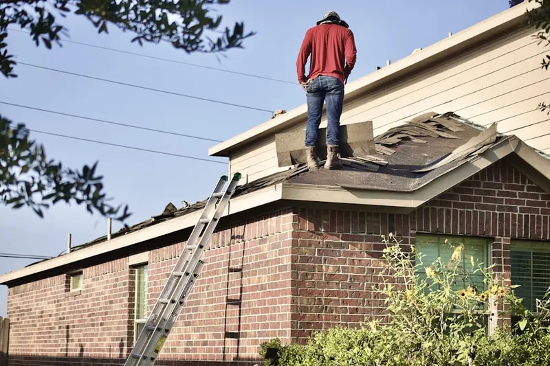 Professional roofer working on a residential roof in Langhorne Manor